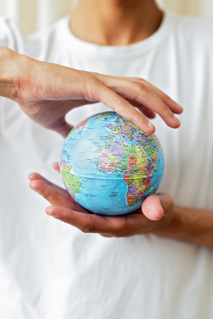 Close-up of hands holding a world globe symbolizing global unity and environmental care.